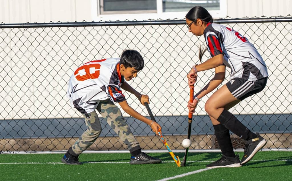 Junior players competing by the fence