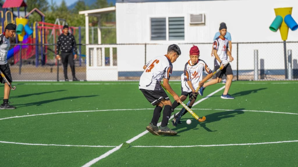 Two young players with hockey sticks on turf