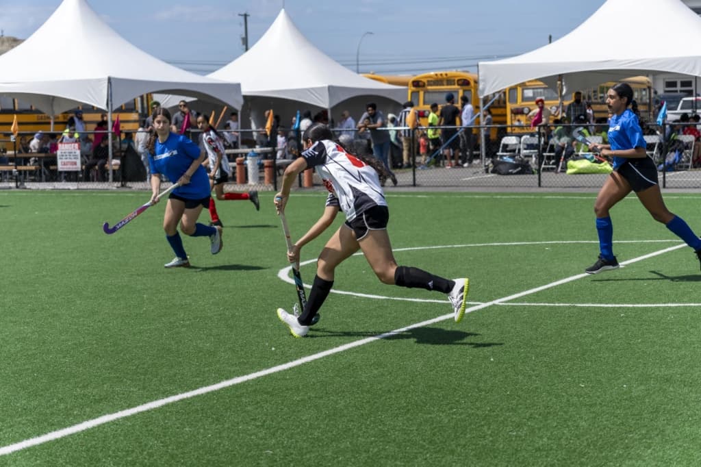 Player tackling with stick during competitive match